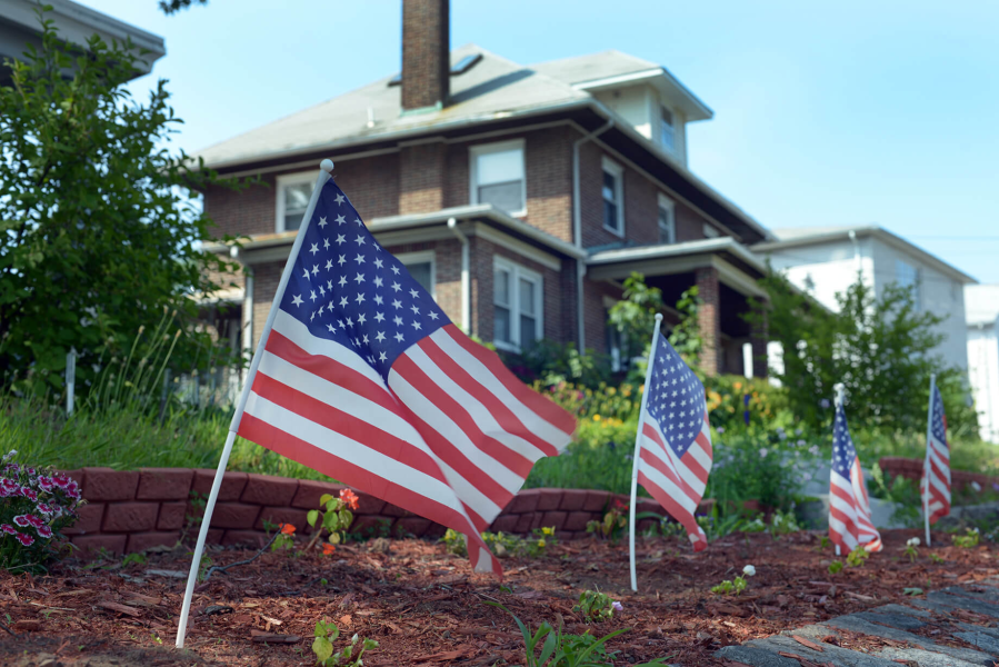 row of american flags in front of a house