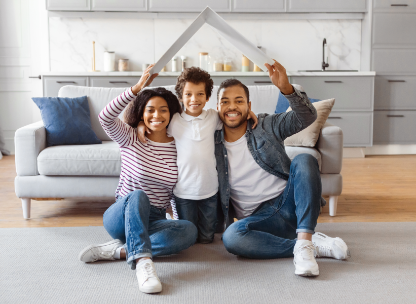 Happy young family sitting on floor of new home